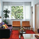 O colorido do tapete, poltronas e sofá aquecem a sala branca